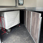 Interior horse area showing the rolling tack chest strapped to the floor beside the wood-effect partition