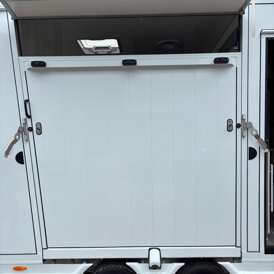 Side horse-loading shutter in the closed position, showing the panel latches on the trailer flank