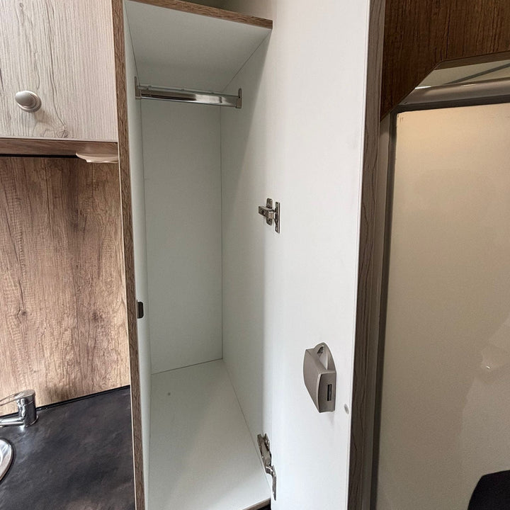 Wardrobe storage cupboard with hanging rail and toilet roll holder inside the living area