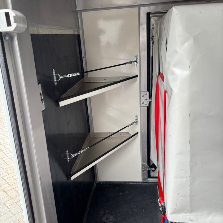 Saddle racks and bridle hooks mounted on the centre partition wall of the horse compartment