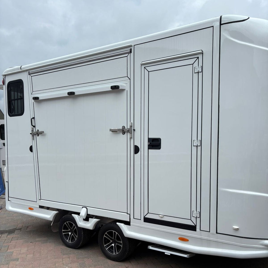 ANKA 2-stall horse trailer exterior side view, white twin-axle with side groom door and sliding side-loading shutter