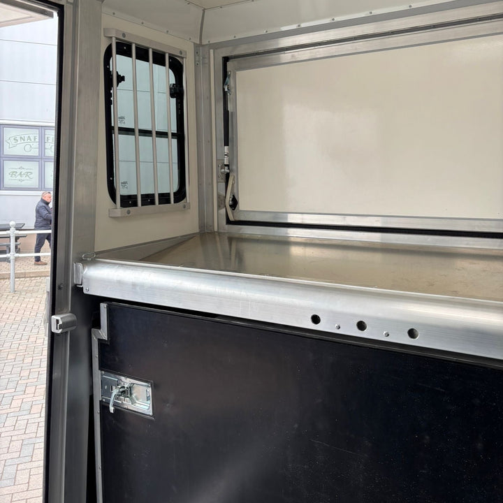 Side groom door open, showing the interior partition and ventilation window from outside