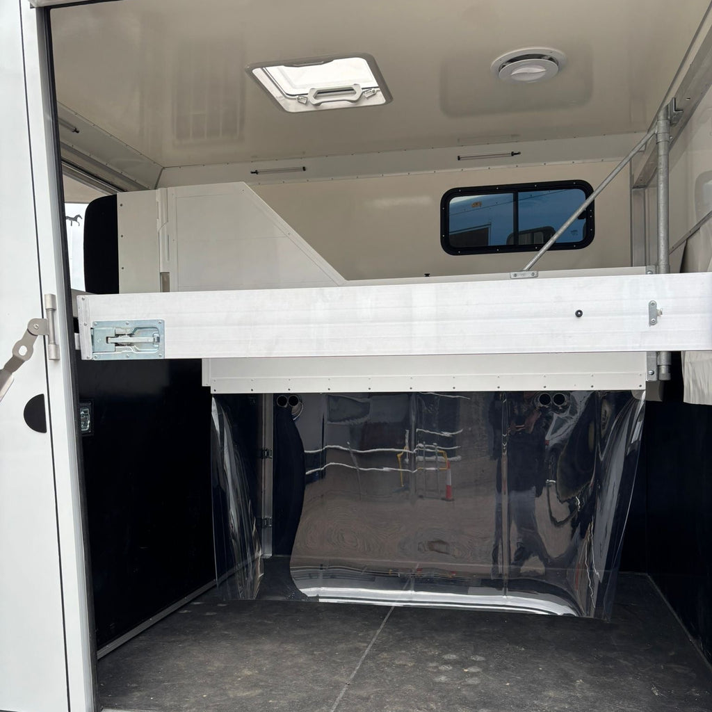 Inside the horse area looking forward, with the overcab bunk space visible above the front bulkhead