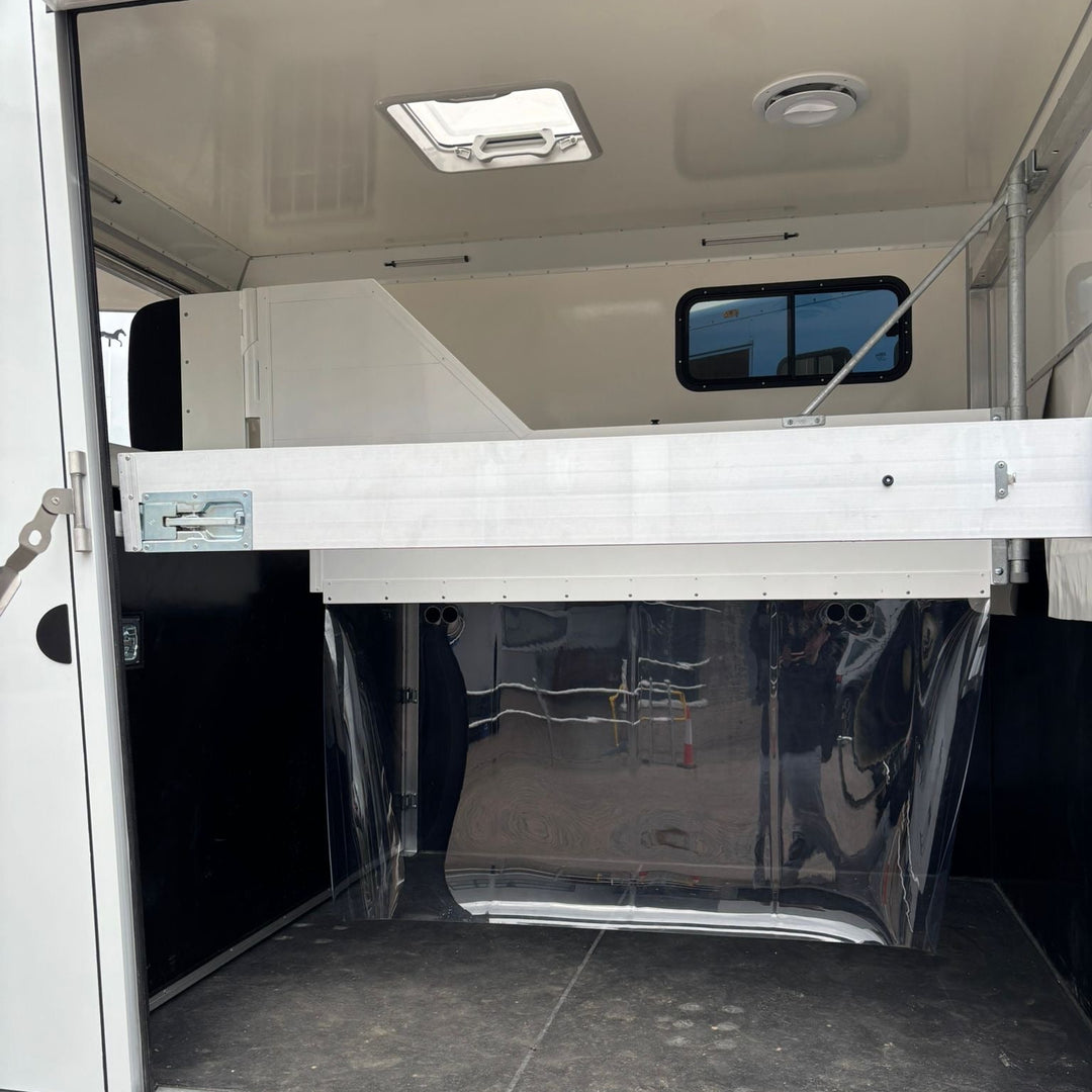 Inside the horse area looking forward, with the overcab bunk space visible above the front bulkhead