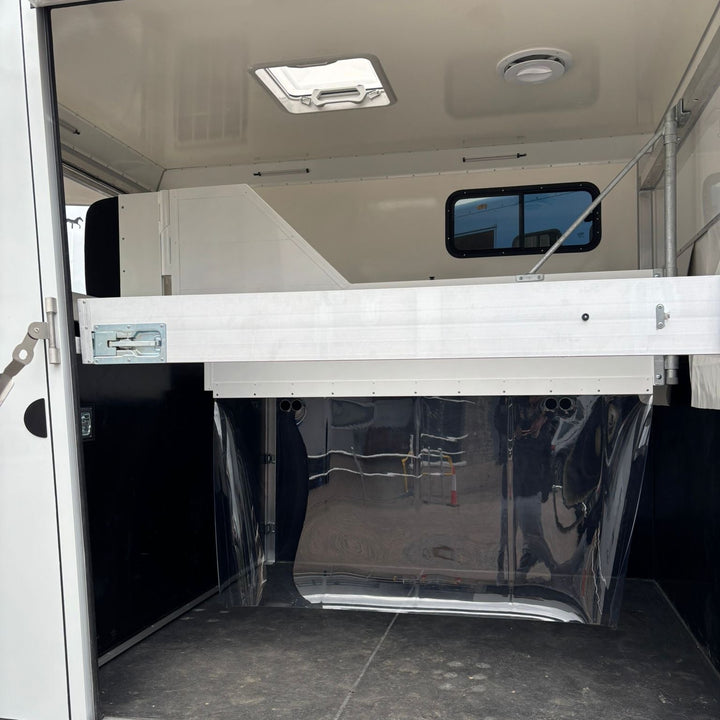 Inside the horse area looking forward, with the overcab bunk space visible above the front bulkhead