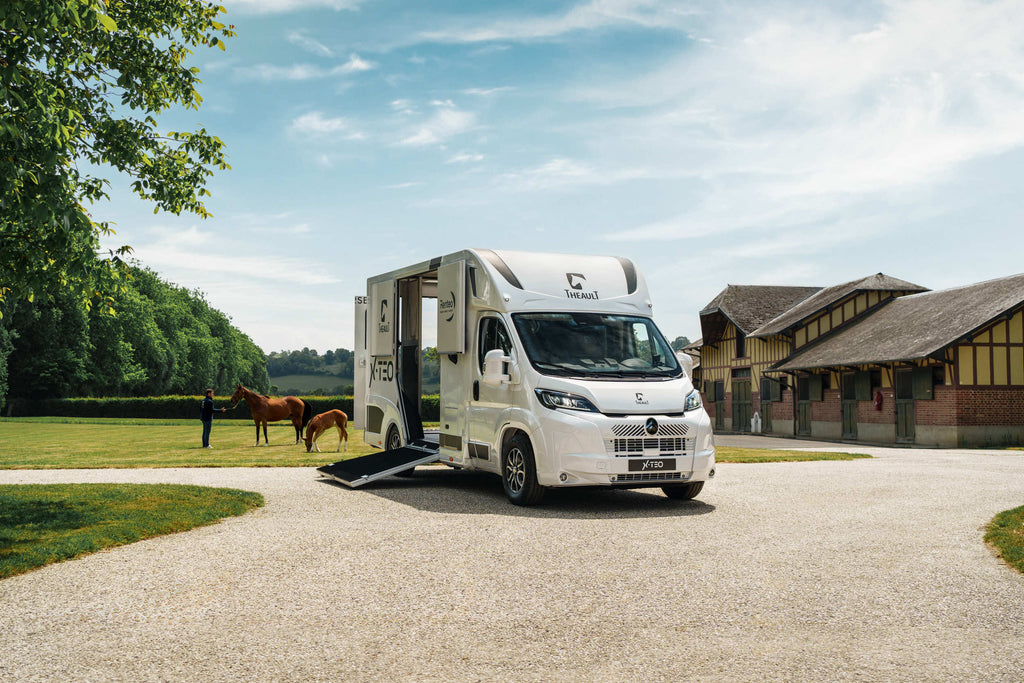 Front three-quarter view of a Theault XTEO horsebox on the Peugeot Boxer chassis in a stable yard