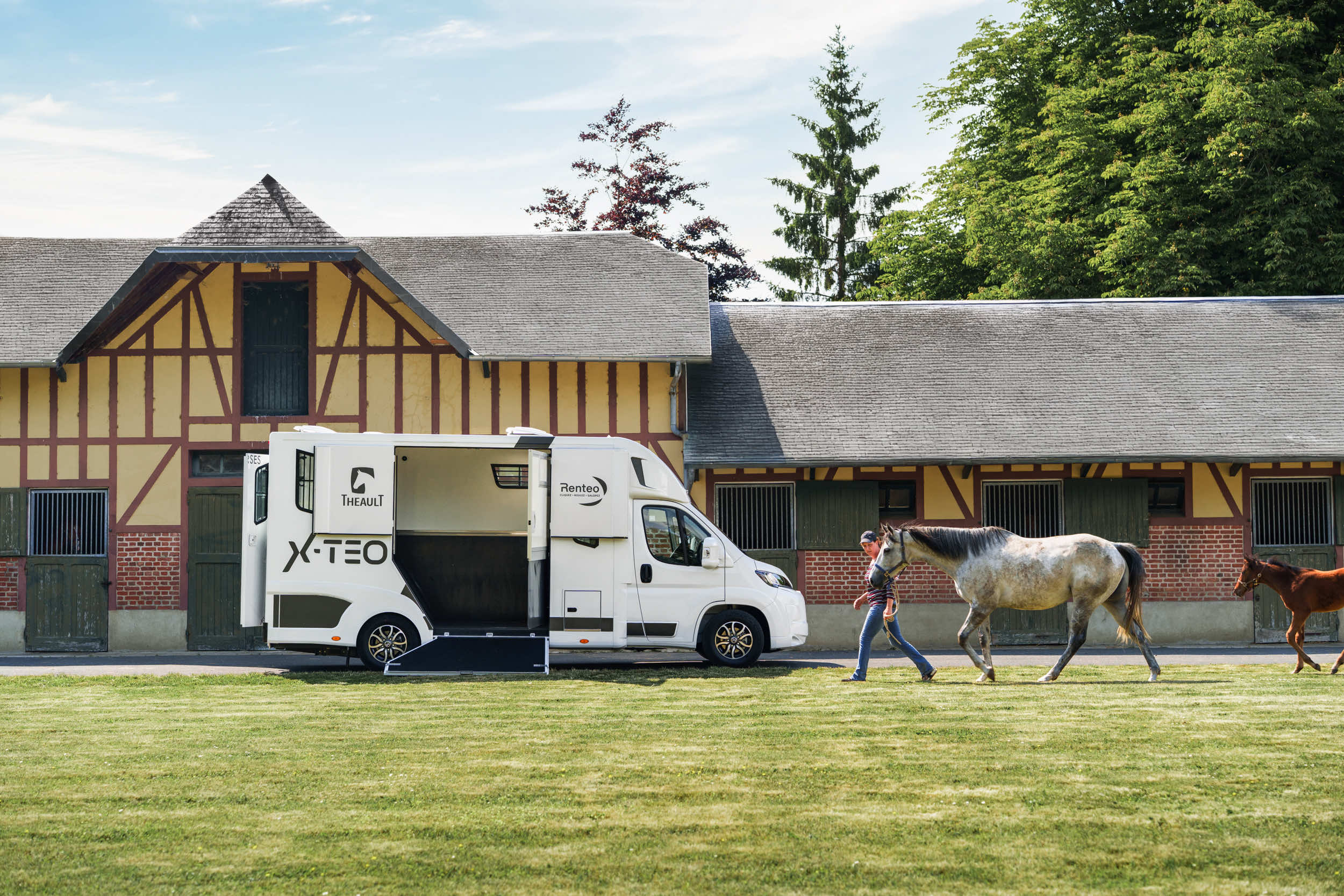 Theault XTEO horsebox in a paddock with a loose horse grazing beside a Normandy stable