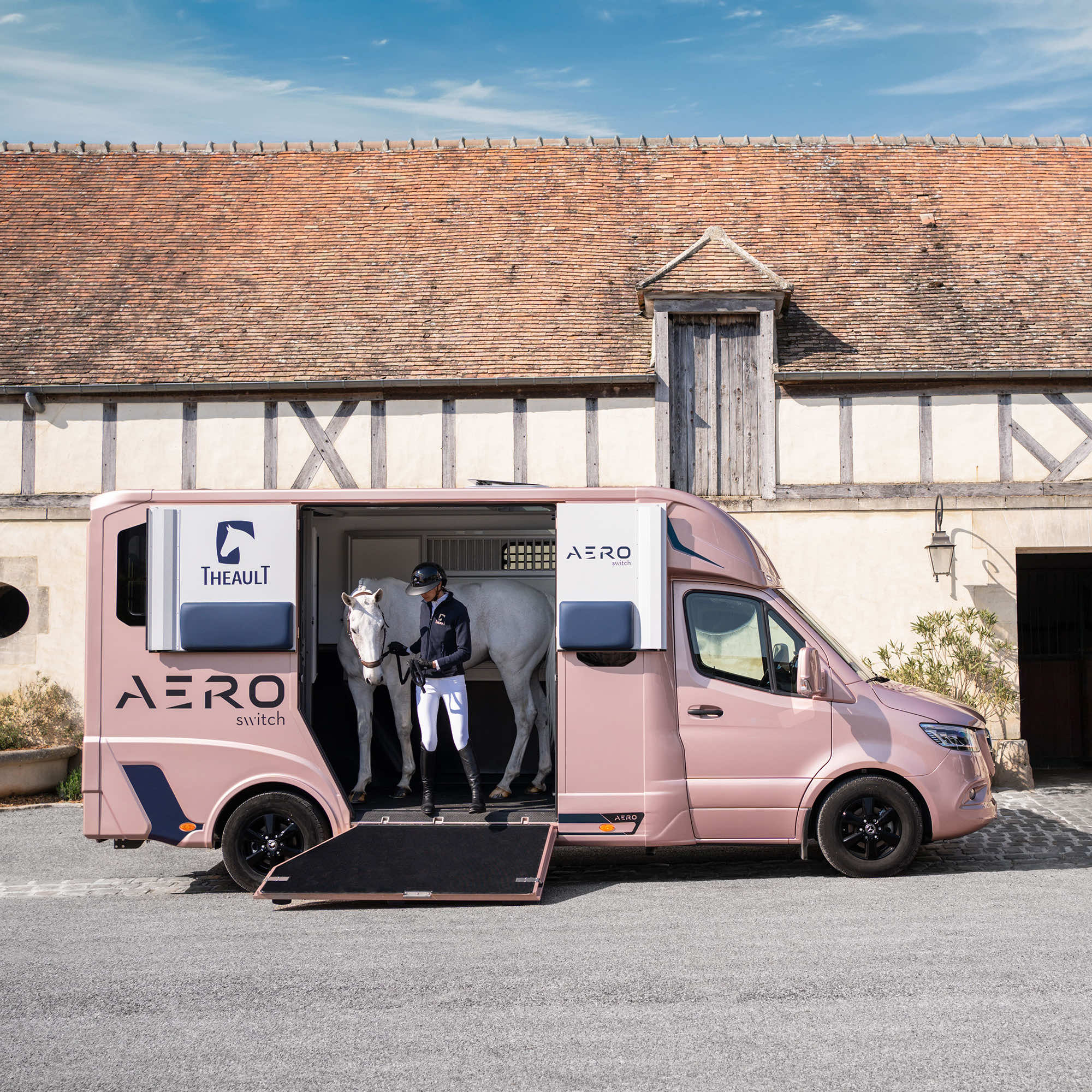 Theault Aero Sprinter horsebox parked in front of a timber-framed Normandy stable