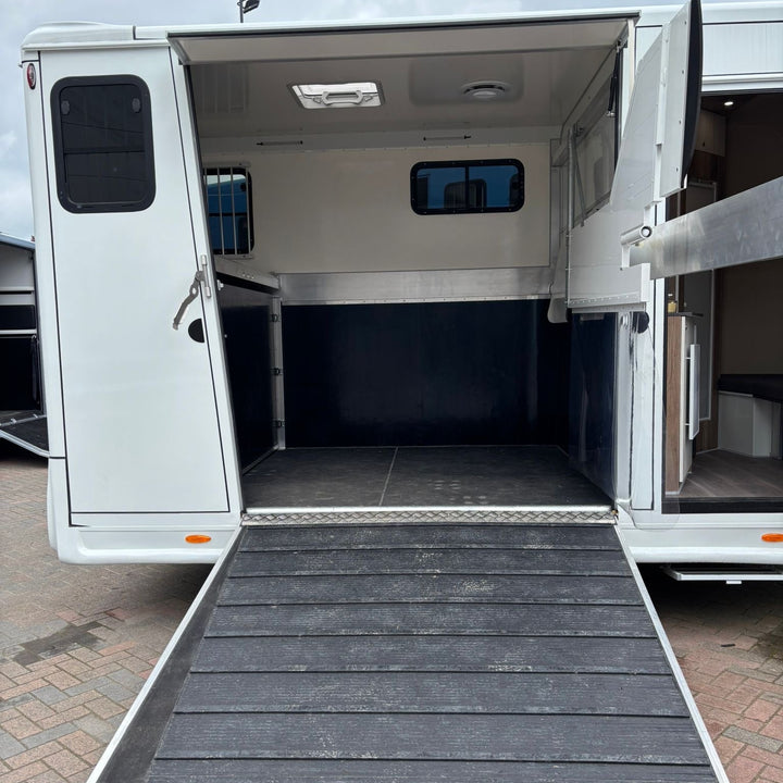 Rear loading ramp deployed, looking into the 2-stall horse compartment with rubber-matted floor