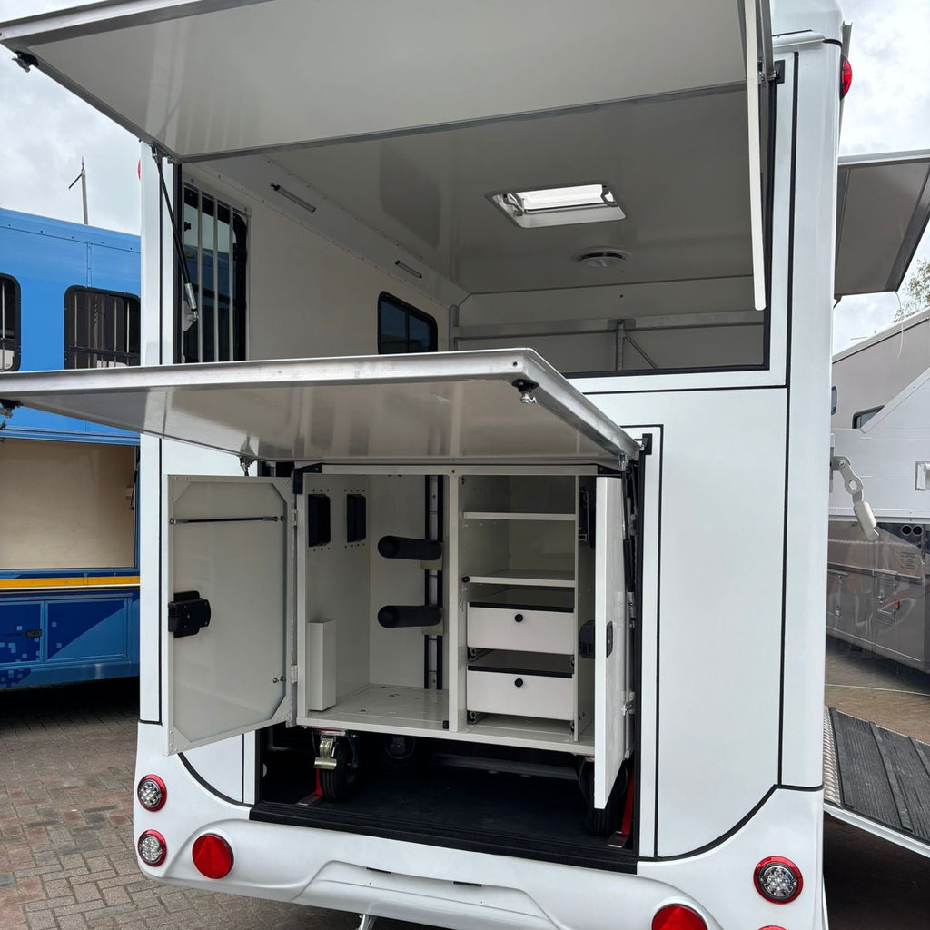 Wide view of the rear tack locker with both upper hatch and lower flap raised, showing organised storage compartments