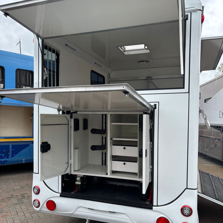 Wide view of the rear tack locker with both upper hatch and lower flap raised, showing organised storage compartments